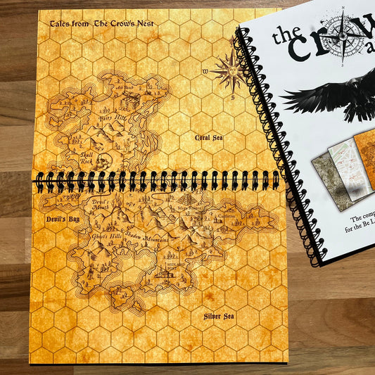 Map book with hexagonal grid design and 'The Crow Atlas' cover on a wooden surface