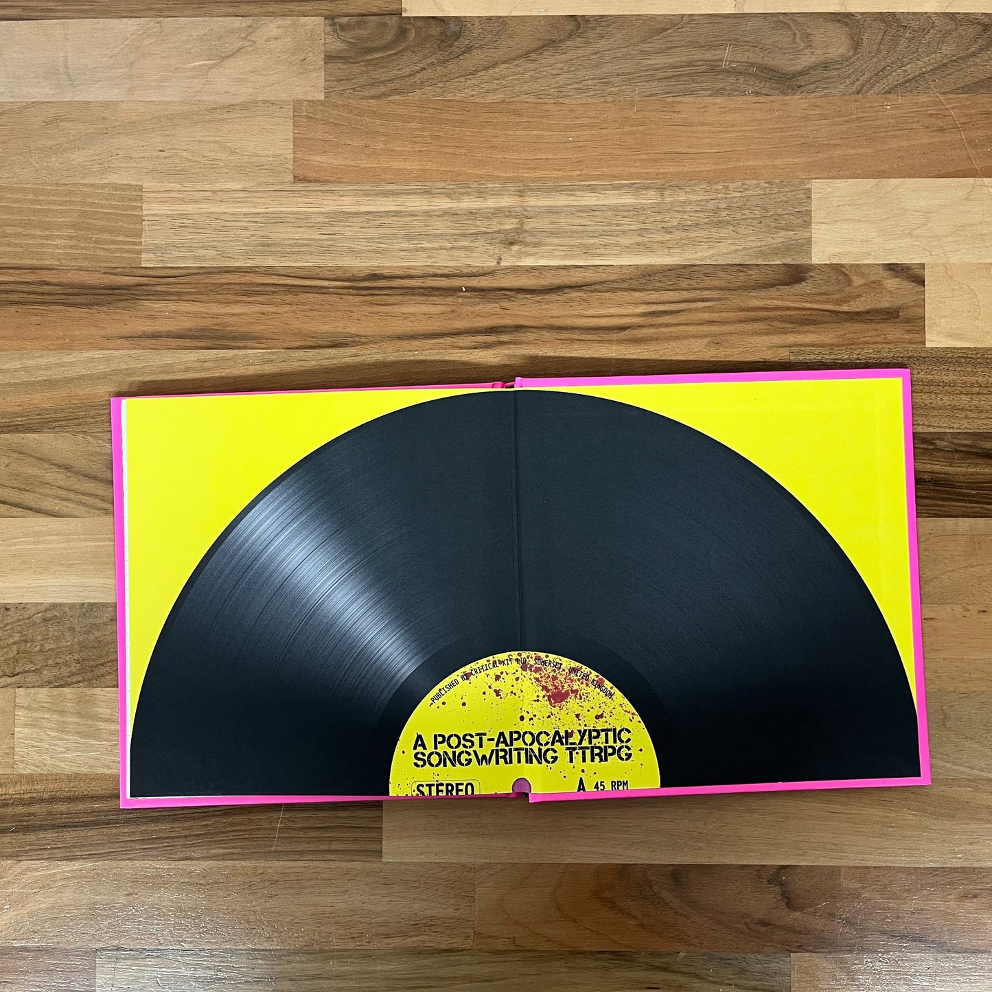 Vinyl record with yellow label on a wooden floor