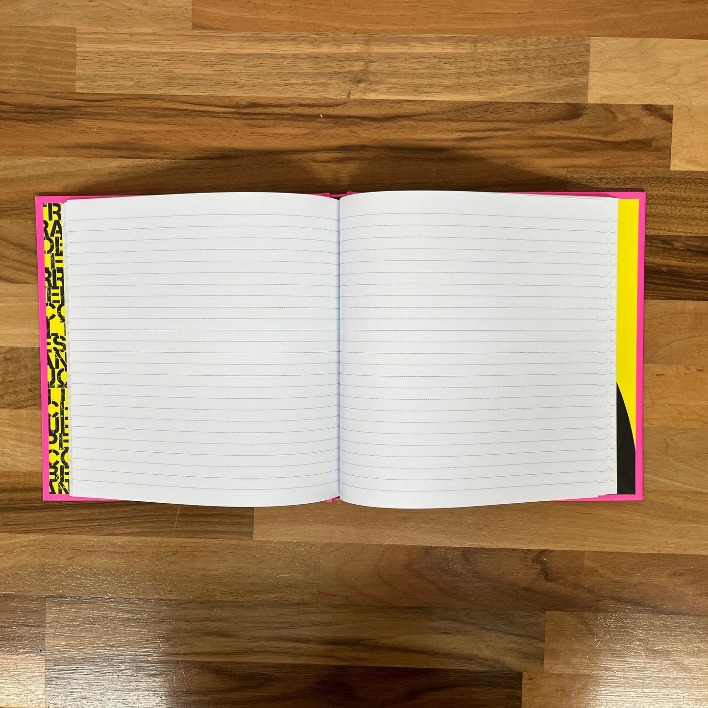 Open notebook with lined pages on a wooden floor