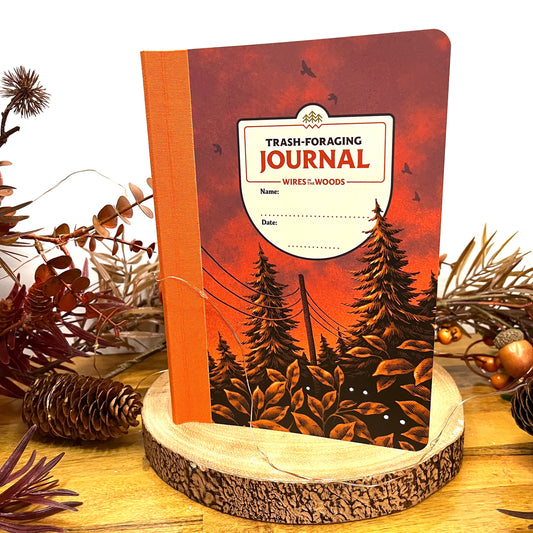 Wires in the Woods journal stood on a wood stand with autumnal follage