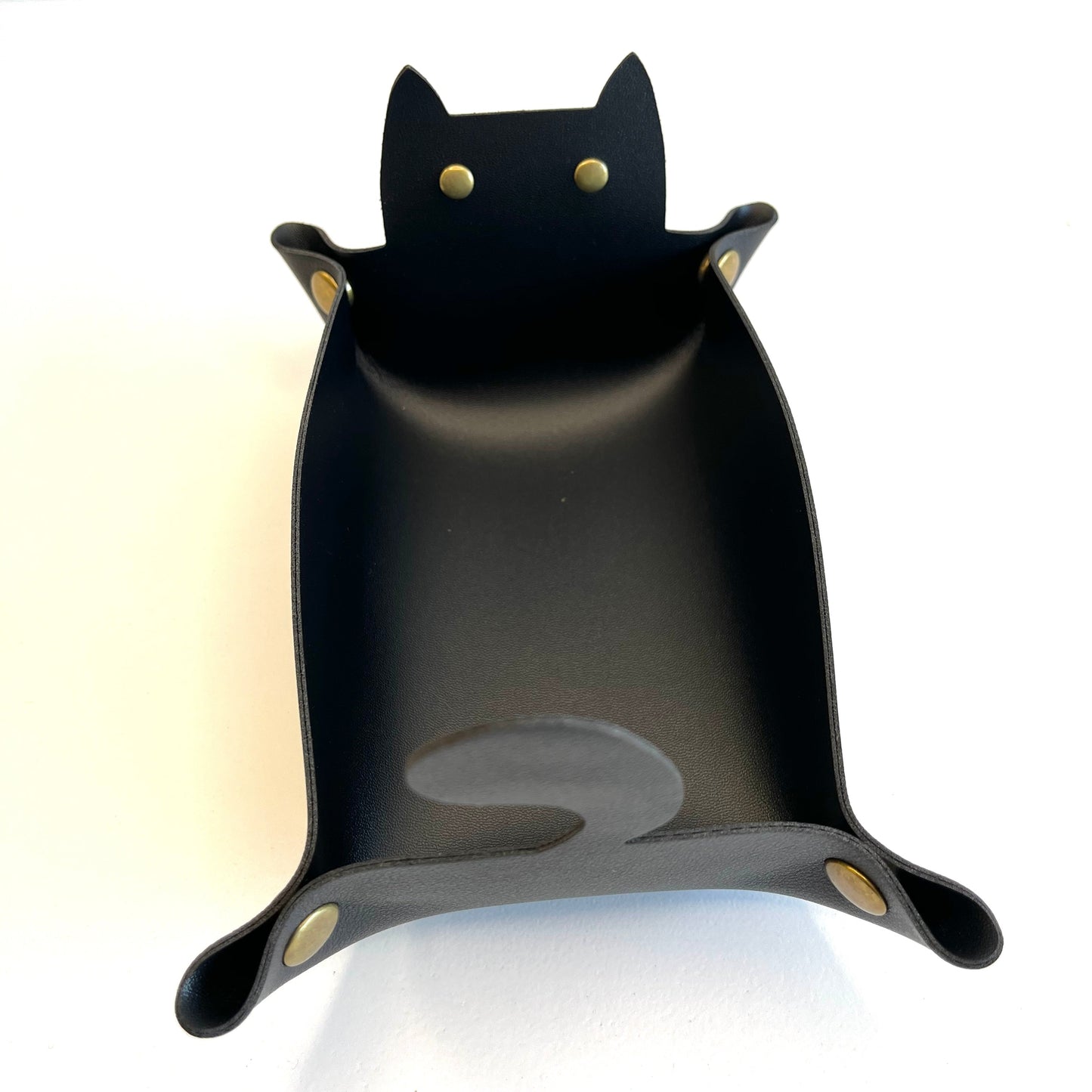 A black cat-shaped dice tray with small gold-tone rivets for eyes and feet, photographed on a plain white background.