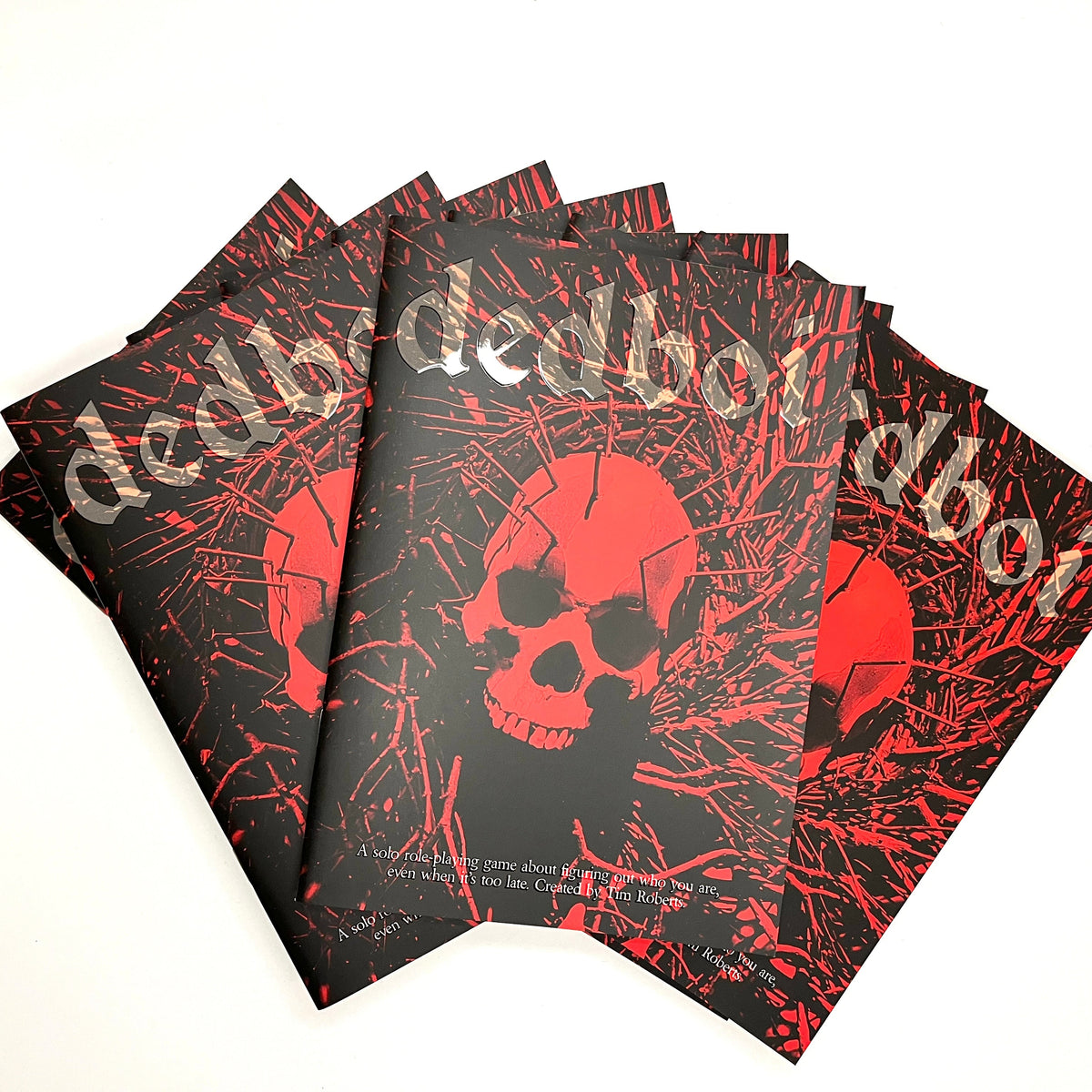 Four copies of the Dedboi solo investigation rpg a plain white background, showing the black cover with red skull and splatter graphics and the title in stylized white lettering.