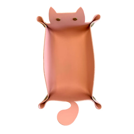 A pink cat-shaped dice tray with pointed ears, small eye cutouts, and a curled tail, photographed on a plain white background.