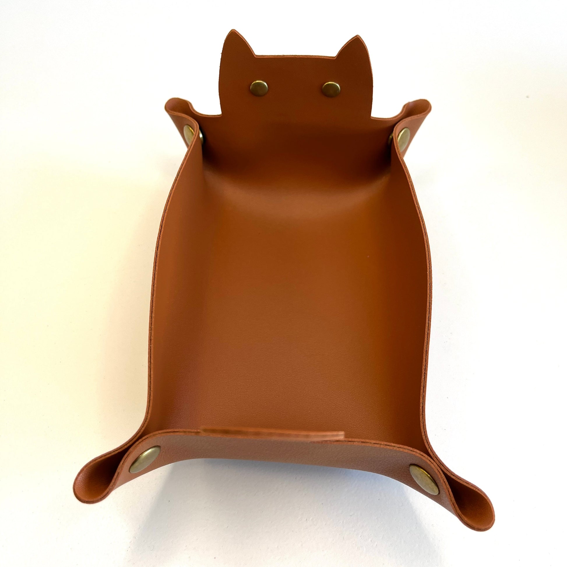 A brown cat-shaped faux-leather dice tray with small metal snap details, photographed on a plain white background.